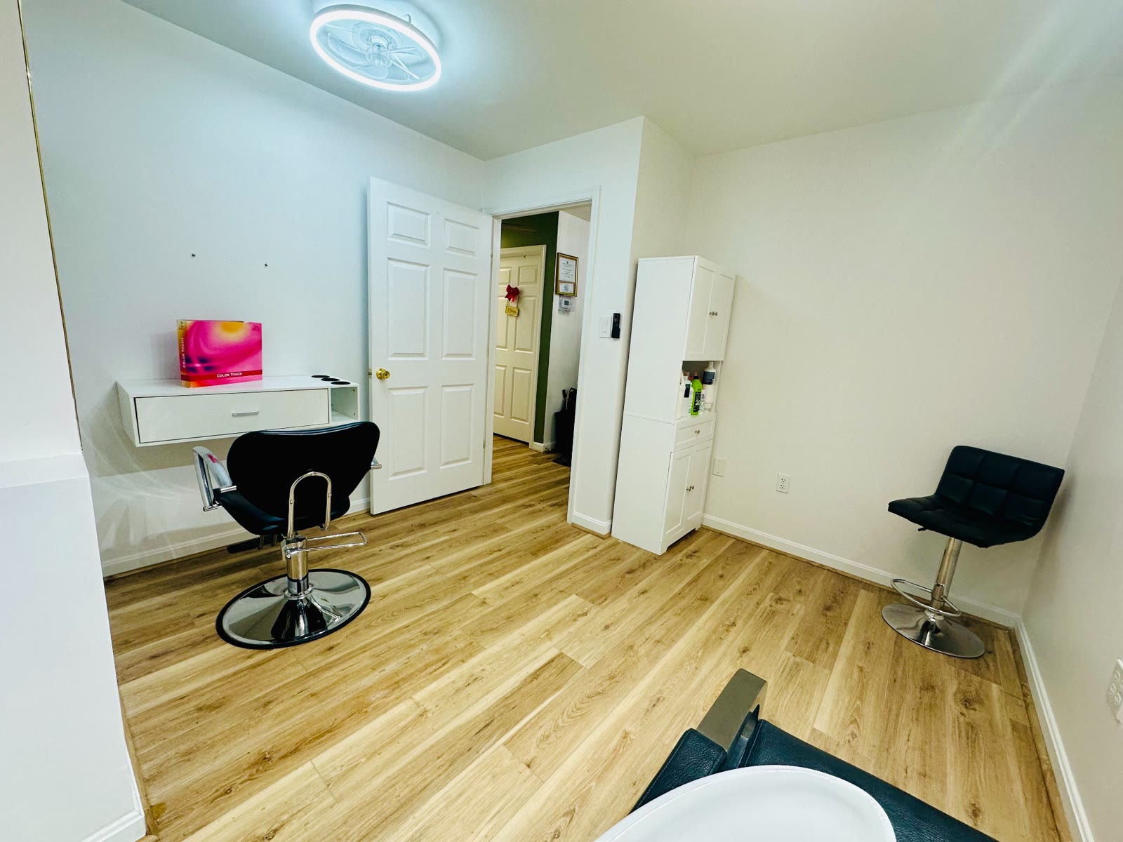 Salon styling chair, storage, and open floor space inside a suite